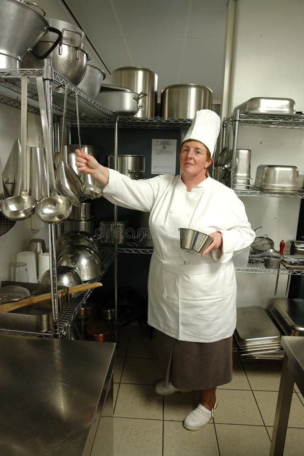 A professional chef standing in her kitchen. A professional chef standing in her kitchen