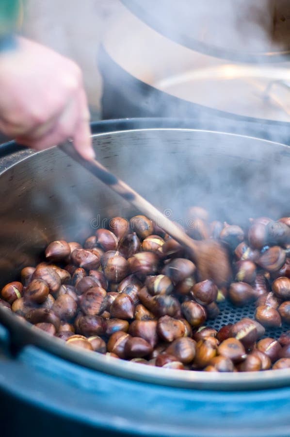 Person makes Roasted Chestnut in a big Pot. Person makes Roasted Chestnut in a big Pot