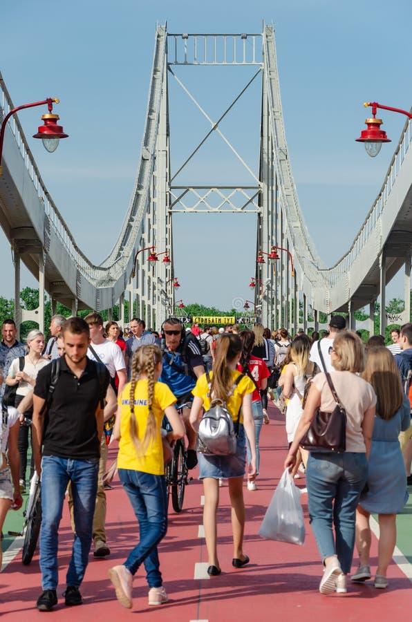 Киев, Украина - 18-ое мая 2019 Мост парка над рекой Dnipro Люди идя вдоль пешеходного моста на выходных стоковое фото Киев, Украина - 18-ое мая 2019 Мост парка над рекой Dnipro Люди идя вдоль пешеходного моста на выходных стоковое фото