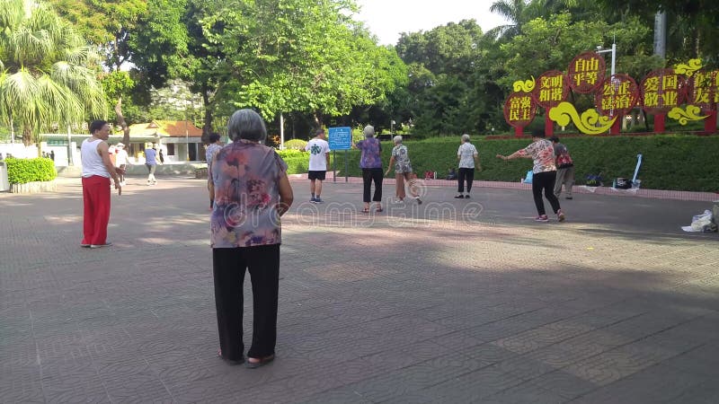 Китай Шеньчжэнь : Пожилые женщины работают в taijiquan на площади парка