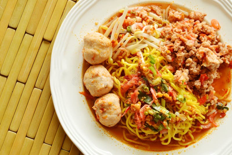 Chinese yellow noodle dressing spicy pork ball with dried shrimp soup on plate. Chinese yellow noodle dressing spicy pork ball with dried shrimp soup on plate