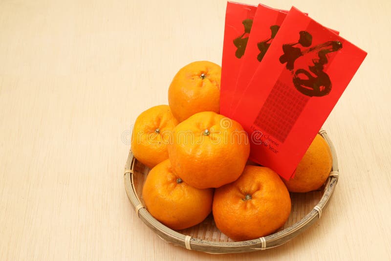 Chinese tangerines in basket with Chinese New year ang pow. Chinese tangerines in basket with Chinese New year ang pow