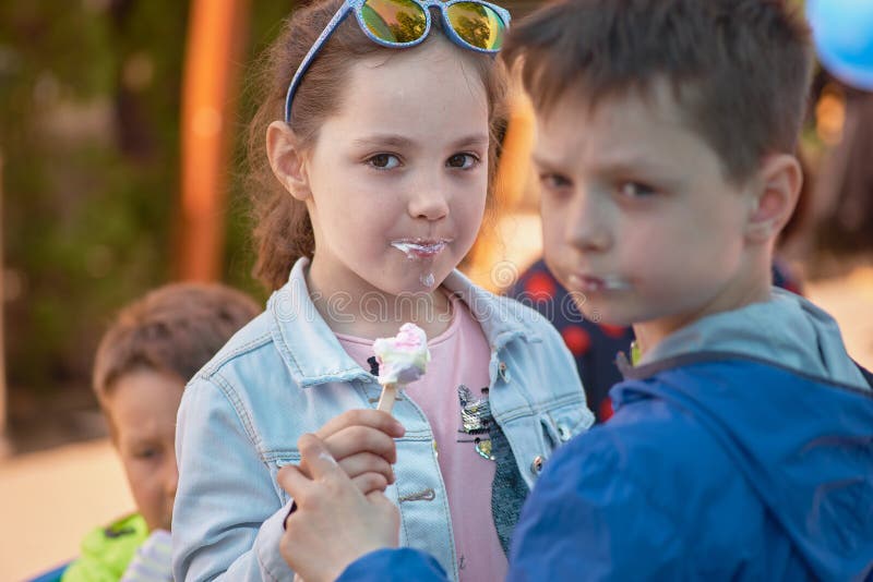 Кишинев, республика Молдавии - 10-ое мая 2019: мороженое распределено бесплатно, девушка с мальчиком наслаждается одним мороженым стоковые фото Кишинев, республика Молдавии - 10-ое мая 2019: мороженое распределено бесплатно, девушка с мальчиком наслаждается одним мороженым стоковые фото