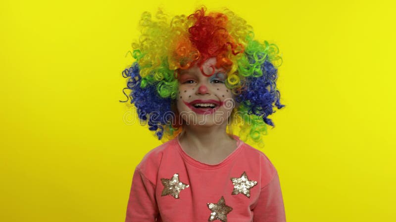 Клоун девушки маленького ребенка в парике rainbow, делающих глупые лица. Будет весело улыбаясь,. Большой палец вверх. Хэллоуин сток-видео