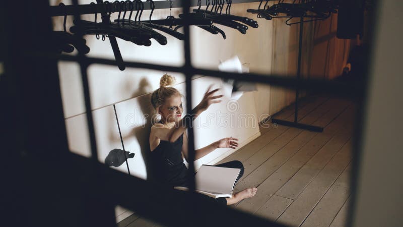 Книга молодого танцора девочка-подростка плача и срывая сидит на поле в ...