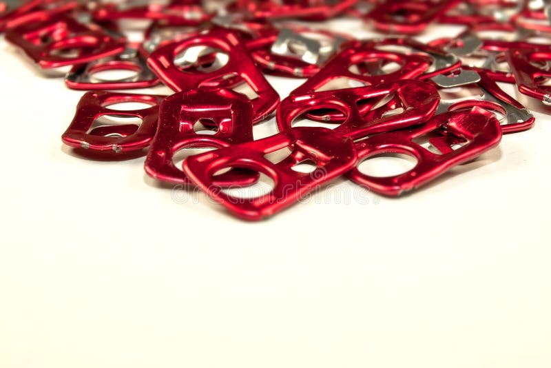 Many red Aluminum can pull ring close up. Many red Aluminum can pull ring close up