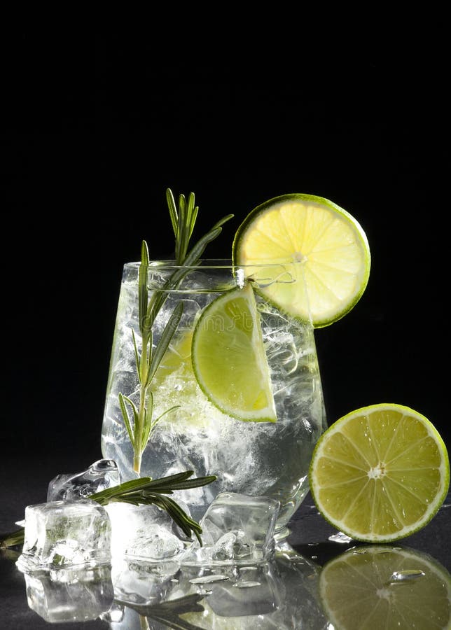 Glass with alcoholic drink with lime and ice on a black background. Glass with alcoholic drink with lime and ice on a black background.