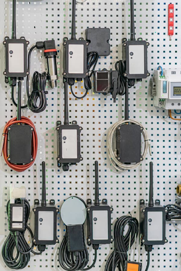 Коллекция электронных блоков управления на белой металлической стойке, соединенных черными кабелями стоковое изображение rf