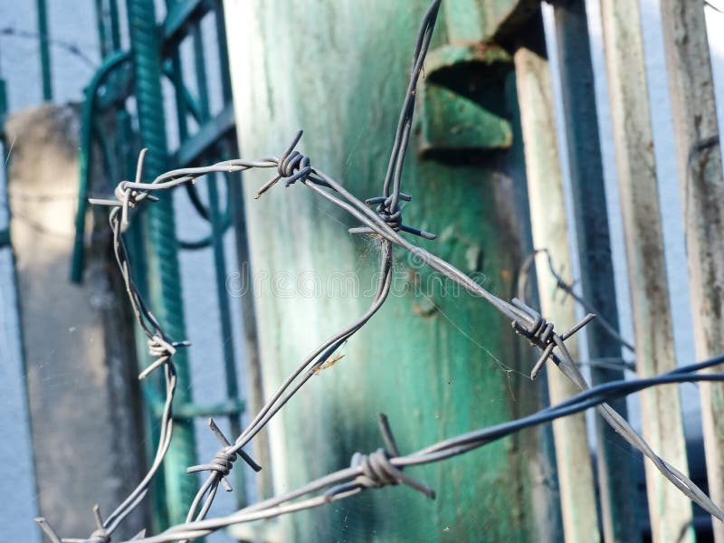 Barbed wire protects private territory. Shallow DOF, focus in the foreground. Barbed wire protects private territory. Shallow DOF, focus in the foreground