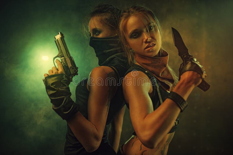 Two dangerous women fighters team with knife and gun. Tattoo on body. Two dangerous women fighters team with knife and gun. Tattoo on body.