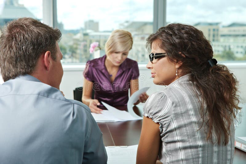 Team of casual looking business people having business meeting at office. Focus place on women in front. Team of casual looking business people having business meeting at office. Focus place on women in front.