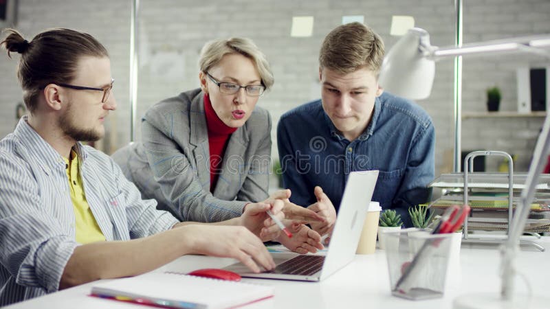 Команда сконцентрированная делом молодых людей наслаждаясь работая совместно, группа millennials говоря имеющ потеху в уютном сток-видео Команда сконцентрированная делом молодых людей наслаждаясь работая совместно, группа millennials говоря имеющ потеху в уютном сток-видео