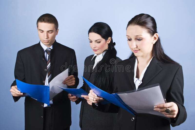 Business team people holding blue folders with contracts and reading in front of blue background,check also. Business team people holding blue folders with contracts and reading in front of blue background,check also