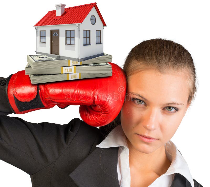 Businesswoman in boxing gloves with bundle of money and house looking at camera on isolated white background. Businesswoman in boxing gloves with bundle of money and house looking at camera on isolated white background