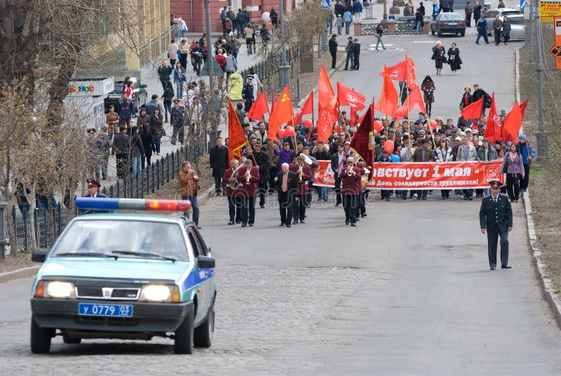 ULAN-UDE, RUSSIA - MAY 1: Communists demonstrate along Lenin Street with an orchestra ahead, convoyed by road police on annual Labour Day, May, 1, 2009 in Ulan-Ude, Buryatia, Russia. ULAN-UDE, RUSSIA - MAY 1: Communists demonstrate along Lenin Street with an orchestra ahead, convoyed by road police on annual Labour Day, May, 1, 2009 in Ulan-Ude, Buryatia, Russia.