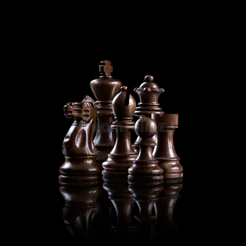 Strategy and leadership concept; black wooden chess figures standing together as a family ready for game against dark background. Strategy and leadership concept; black wooden chess figures standing together as a family ready for game against dark background.