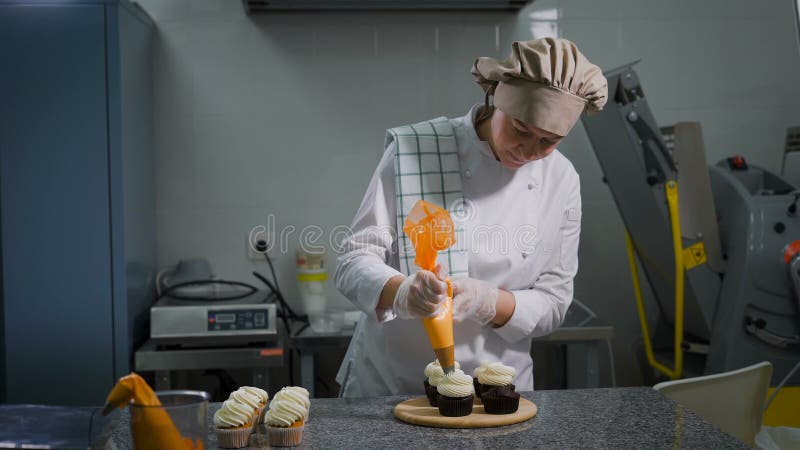 Кондитерская Шеф-повар украшает заказ на праздник Женщина сделала шоколадные торты для того чтобы приказать Булочки на деревянной