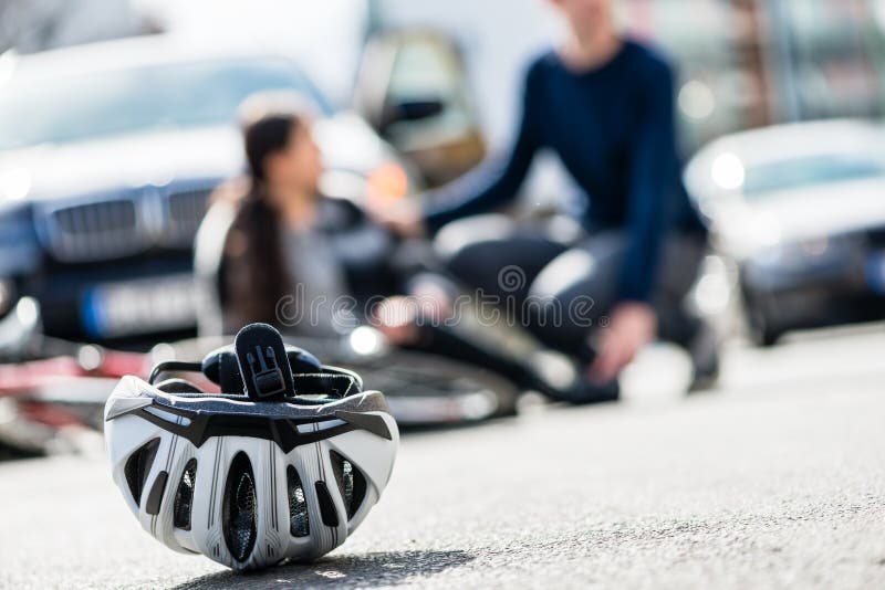 Close-up of a bicycling helmet fallen down on the ground after accidental collision between bicycle and a 4x4 car. Close-up of a bicycling helmet fallen down on the ground after accidental collision between bicycle and a 4x4 car