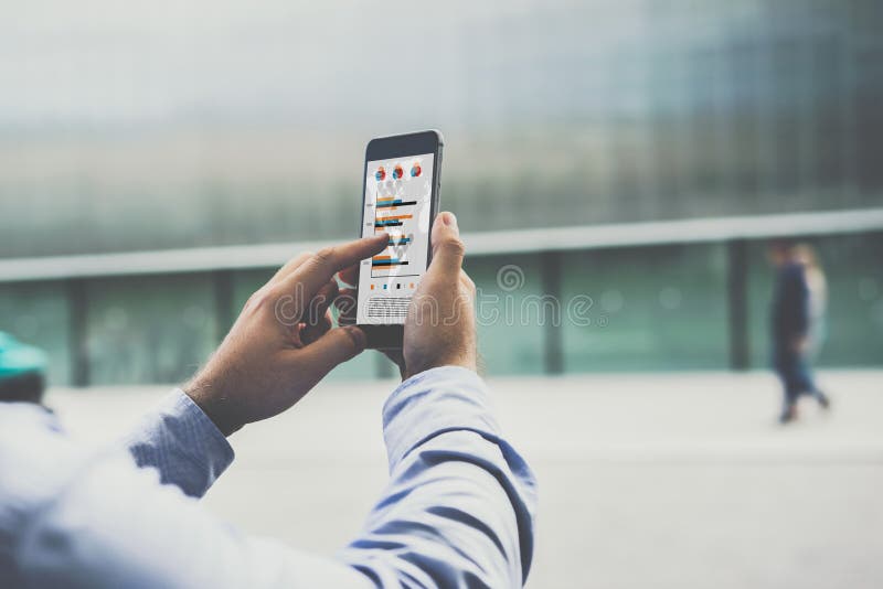 Конец-вверх smartphone с диаграммами, диаграммами и диаграммами на экране в мужских руках стоковые фото