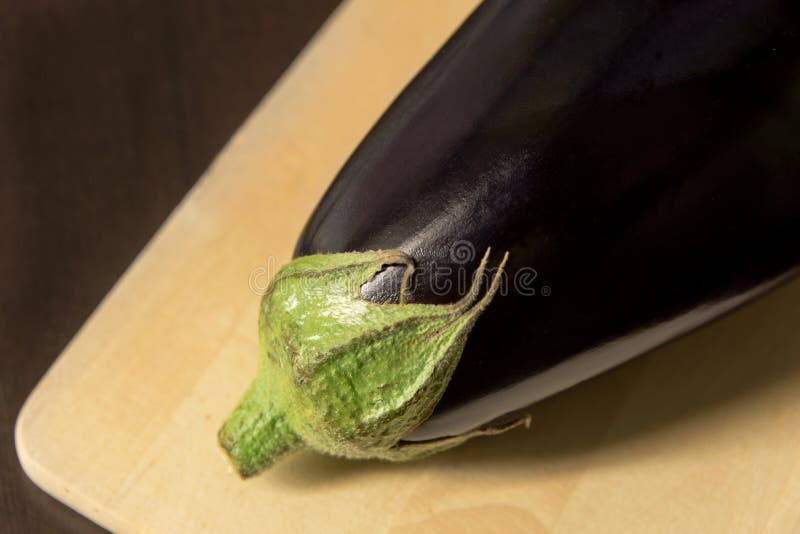 Конец-вверх баклажана, aubergine на разделочной доске на темной предпосылке стоковое фото Конец-вверх баклажана, aubergine на разделочной доске на темной предпосылке стоковое фото
