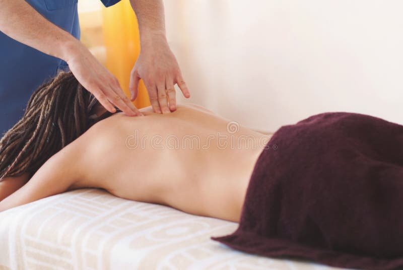 Конец-вверх рук masseur делая задний массаж стоковые изображения Конец-вверх рук masseur делая задний массаж стоковые изображения