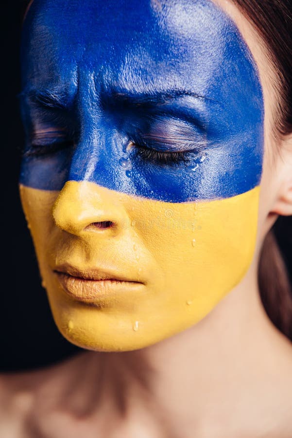 Конец по представлению молодой женщины с цветным украинским флагом на плач кожи стоковая фотография rf