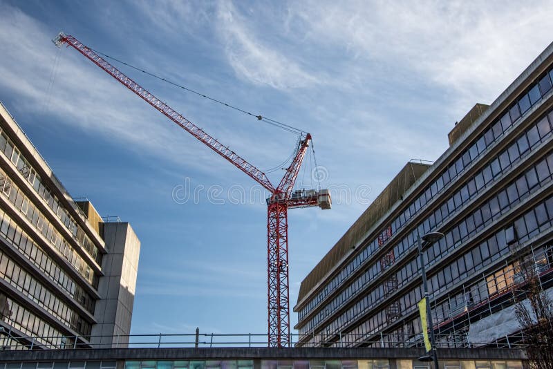 Конструкция центра города Массивнейший красный кран между buildi офиса стоковое фото Конструкция центра города Массивнейший красный кран между buildi офиса стоковое фото