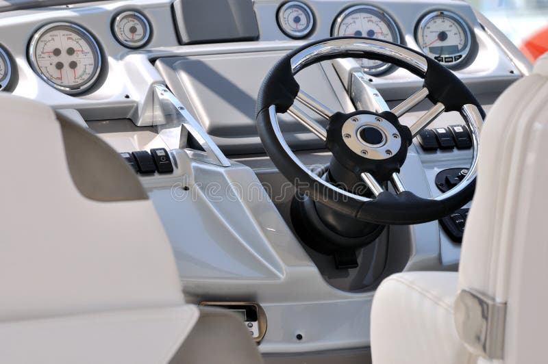 Steering wheel and gage in small yacht, shown as entertainment, holiday or marine activity. Steering wheel and gage in small yacht, shown as entertainment, holiday or marine activity.