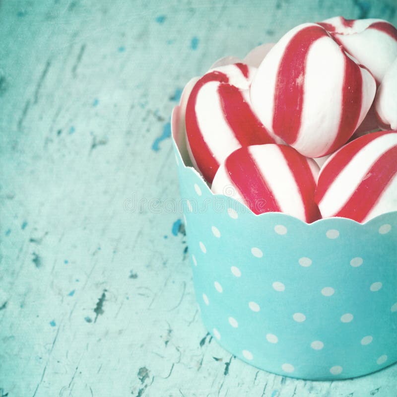 Peppermint candy in light blue paper cupcake with textured vintage editing. Peppermint candy in light blue paper cupcake with textured vintage editing