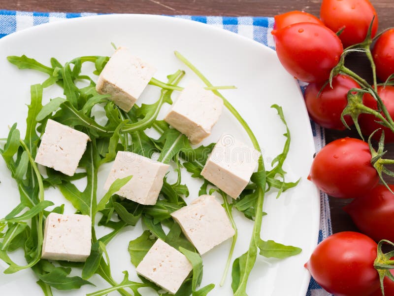 Концепция еды Vegan с тофу, arugula и томатами стоковое фото rf Концепция еды Vegan с тофу, arugula и томатами стоковое фото rf