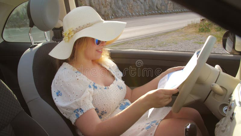 концепция летних каникул и автопутешествий. девушка-путешественница, сидящая в машине и смотрящая на карту
