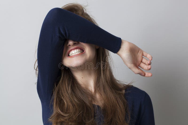 Despair and anger concept - shocked young woman hiding her face with her arm,grinding teeth for dramatic resignation,studio shot. Despair and anger concept - shocked young woman hiding her face with her arm,grinding teeth for dramatic resignation,studio shot