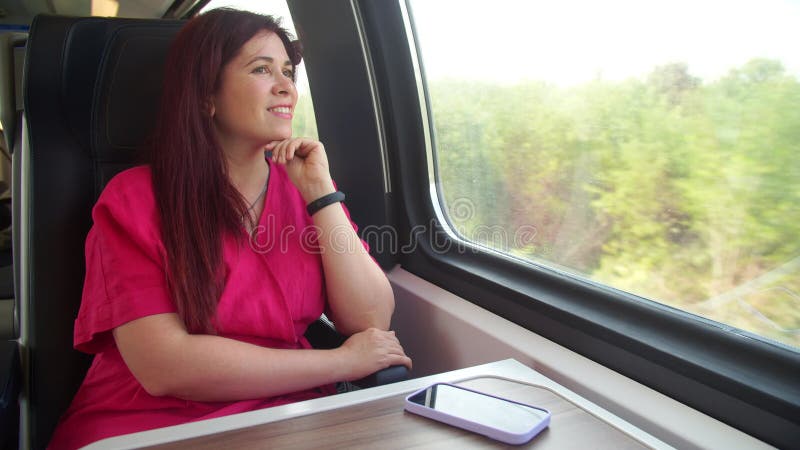 концепция поездки между городами. женщина, которая смотрит в окно, сидя в поезде