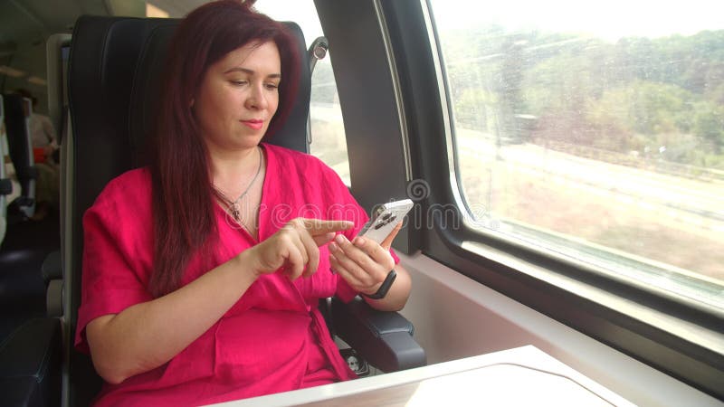 концепция поездок на общественном транспорте. женщина с помощью приложения для смартфона фотографирует вид во время поездки в поез