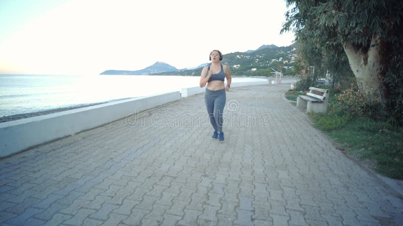 концепция спорта и фитнеса. молодая женщина плюс женщина, использующая фитнес-трекер во время пробежки на свежем воздухе