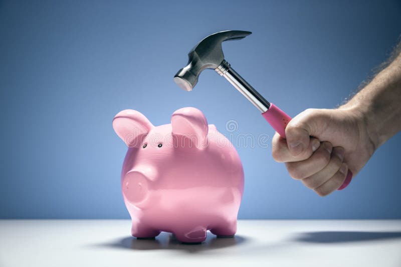 Pink piggy bank money box and hand with hammer about to hit and smash to get at savings. Pink piggy bank money box and hand with hammer about to hit and smash to get at savings