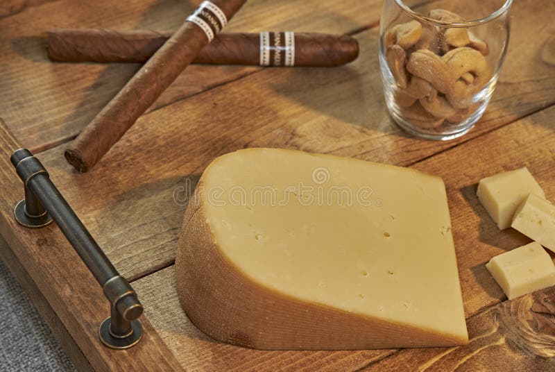 Копченый сыр гауда с кубинськими сигарами стоковые изображения Копченый сыр гауда с кубинськими сигарами стоковые изображения