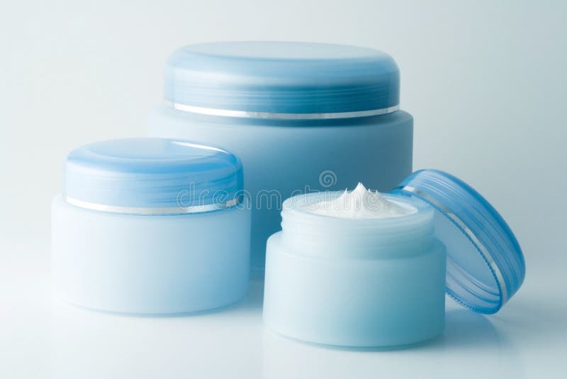 Containers of three different cosmetic creams. Containers of three different cosmetic creams