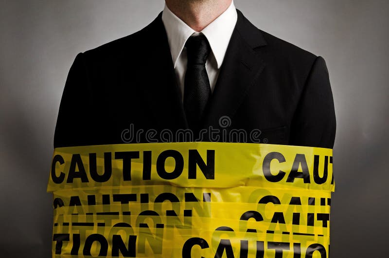 Image of a man wearing a suit wrapped in caution tape. Image of a man wearing a suit wrapped in caution tape