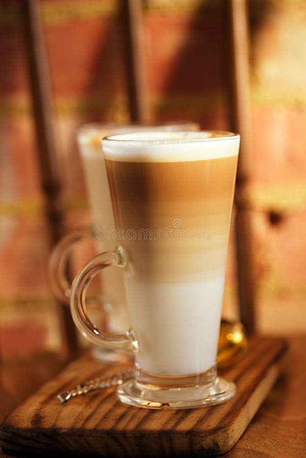 Кофе Latte в высокорослых стеклах на винтажном стуле с старым кирпичом wal стоковое фото