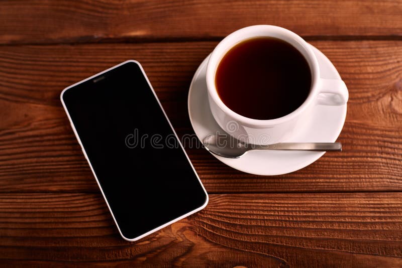 Кофе и мобильный телефон Smartphone и чашка эспрессо на деревянном столе Устройство стоковая фотография Кофе и мобильный телефон Smartphone и чашка эспрессо на деревянном столе Устройство стоковая фотография