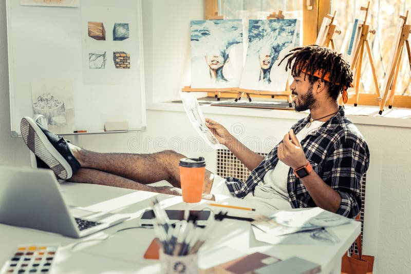 Кофе и работа бородатого темн-с волосами дизайнера по интерьеру выпивая стоковые фото