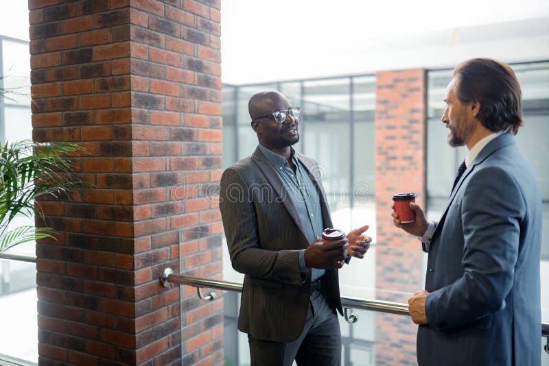 Кофе утра бородатого бизнесмена выпивая с коллегой стоковое изображение