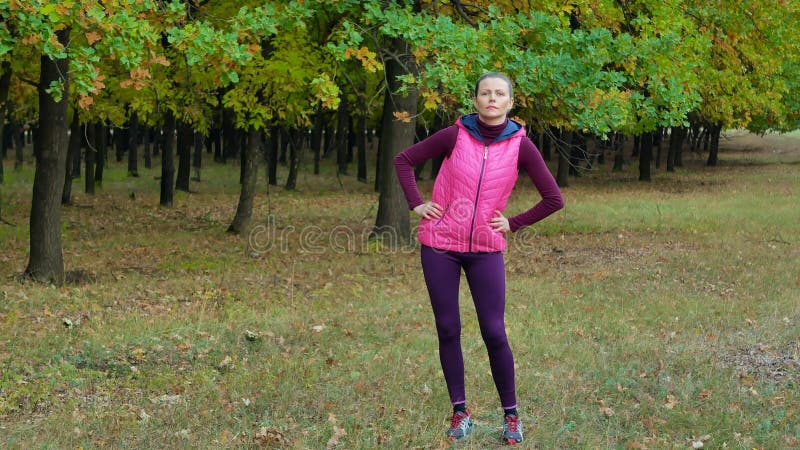 Красивая девушка спорта фитнеса нагревает перед бежать в парке осени Разминка Outdoors