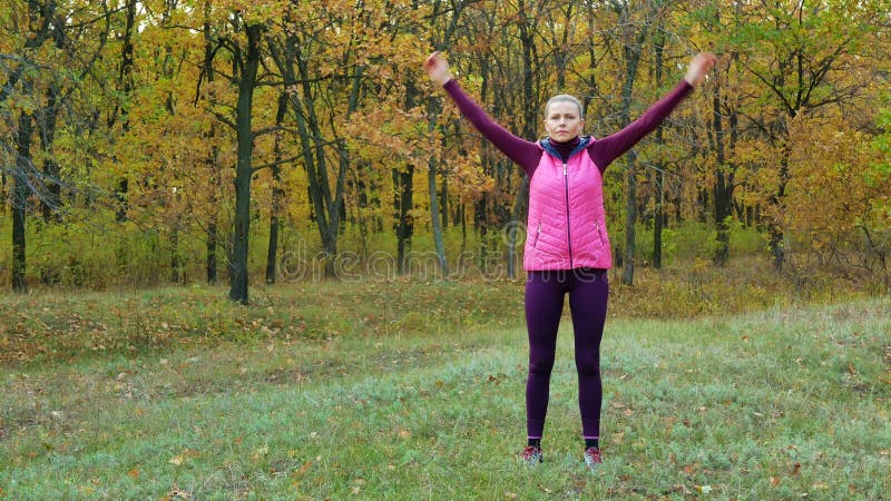Красивая девушка спорта фитнеса нагревает перед бежать в парке осени Разминка Outdoors