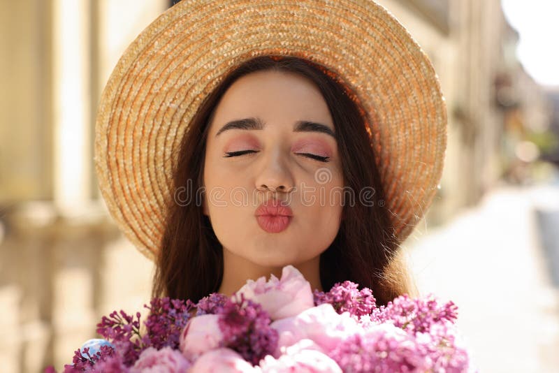 Beautiful woman with bouquet of spring flowers sending air kiss. Beautiful woman with bouquet of spring flowers sending air kiss