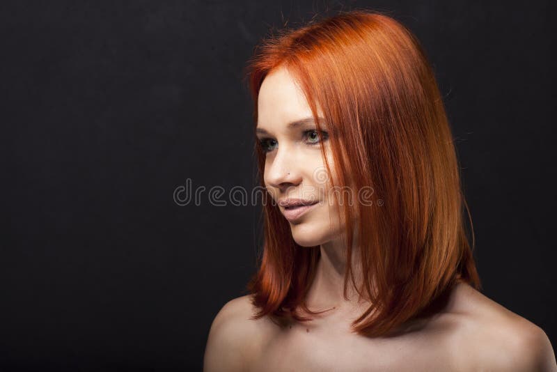 Красивая молодая девушка с ориентацией, сильный портрет redhead на темной предпосылке стоковая фотография