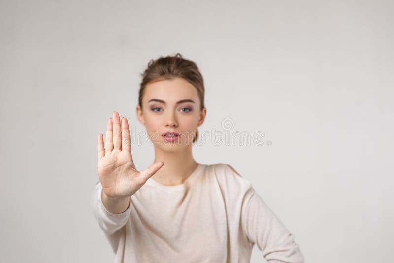 Beautiful young woman making stop gesture on gray background. Beautiful young woman making stop gesture on gray background.