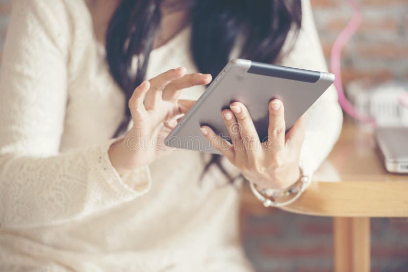 Красивая молодая женщина носит белое платье шнурка используя Ipad пока сидящ в кофейне для того чтобы исследовать вебсайт стоковая фотография Красивая молодая женщина носит белое платье шнурка используя Ipad пока сидящ в кофейне для того чтобы исследовать вебсайт стоковая фотография