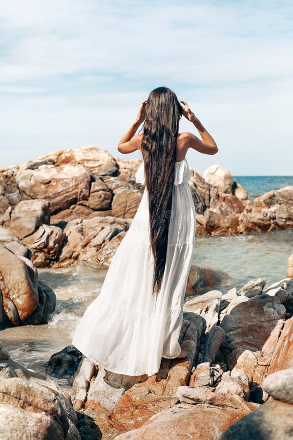 Красивая молодая женщина стиля boho в белом платье стоя на ston стоковая фотография Красивая молодая женщина стиля boho в белом платье стоя на ston стоковая фотография
